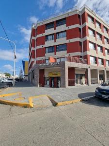 a red building with a car parked in front of it at departamentos lasserre in Río Grande