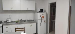 uma cozinha com armários brancos e um frigorífico branco em Los Zorzales Centro em Mendoza