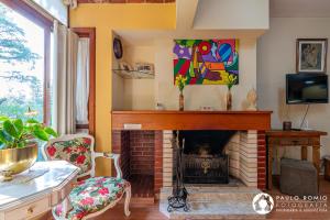 uma sala de estar com lareira e uma pintura na parede em Apartamento Aluguel Temporada Gramado em Gramado
