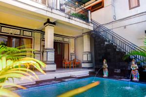 
a swimming pool with a pool table and chairs at Adi Homestay in Canggu
