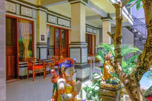 a house with a statue in front of a porch at Adi Homestay in Canggu