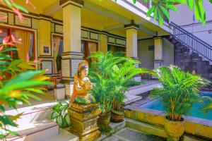 una casa con una statua di fronte a una piscina di Adi Homestay a Canggu