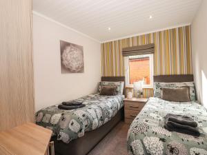 a bedroom with two beds and a window at Ridgway Lodge in Windermere
