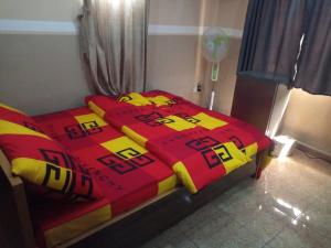 un letto con una coperta rossa e gialla sopra di The Edgewood Manor, Entire Service apartment with 24 hours power ad Akure