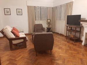 - un salon avec un canapé, une chaise et une télévision dans l'établissement Casa frente al parque San Martín zona residencial, à Mendoza