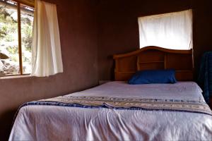 Bett in einem Zimmer mit Fenster in der Unterkunft TAQUILE LODGE - Un lugar de ensueño in Huillanopampa
