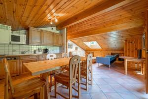 eine Küche mit einem großen Holztisch und Stühlen in der Unterkunft Gentiane Furnished flat in Les Houches