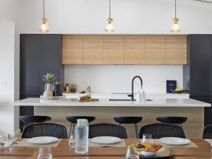 a kitchen with a table and chairs and a counter at Ocean Scene in Fingal Bay +13 photos