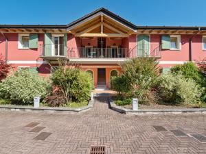 a large pink house with a brick driveway at Amazing Apartment in Idro with Shared Pool in Crone