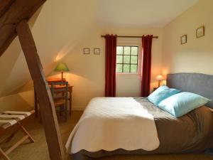 Schlafzimmer mit einem Bett und einem Fenster mit roten Vorhängen in der Unterkunft Charming half-timbered house on quiet waterside between Abbeville and Amiens in Fransu