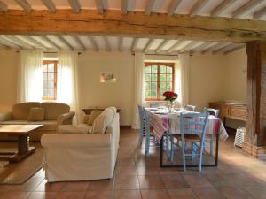 ein Wohnzimmer mit einem Tisch und Stühlen in der Unterkunft Charming half-timbered house on quiet waterside between Abbeville and Amiens in Fransu
