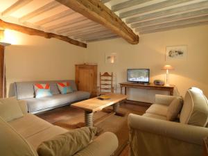 ein Wohnzimmer mit einem Sofa und einem Tisch in der Unterkunft Charming half-timbered house on quiet waterside between Abbeville and Amiens in Fransu