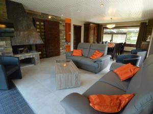 a living room with couches and a table and a fireplace at Elegant villa in Stavelot with fitness playroom in Stavelot