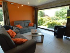a living room with couches and a table at Elegant villa in Stavelot with fitness playroom in Stavelot