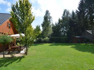 un ampio cortile con un tavolo da picnic e un albero di Wooden villa on the Veluwe a Wissel
