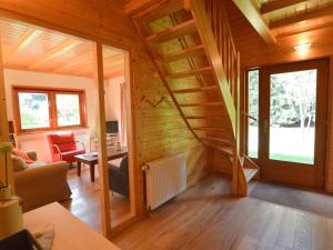 ein Wohnzimmer mit einer Treppe in einem Holzhaus in der Unterkunft Wooden villa on the Veluwe in Wissel