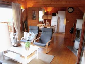 un soggiorno con tavolo e sedie e una cucina di Comfortable holiday home near the lake a Beaulieu