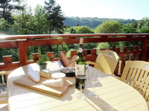 un tavolo con una bottiglia di vino e bicchieri da vino di Comfortable holiday home near the lake a Beaulieu
