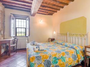 a bedroom with a bed and a desk and a window at Farmhouse by Lake Trasimeno with Pool in Pucciarelli