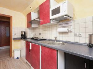 a kitchen with a sink and a microwave at Peaceful Forest Getaway in Altenfeld