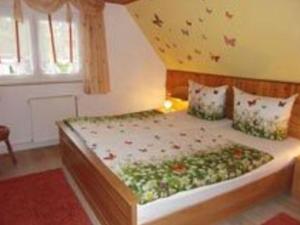 ein Schlafzimmer mit einem Bett mit Blumen darauf in der Unterkunft Holiday home in Saxon Switzerland quiet location big garden grilling area in Lichtenhain