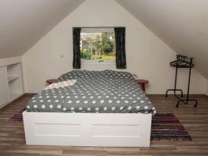 uma cama branca num quarto com uma janela em Holiday home with covered terrace em Groet
