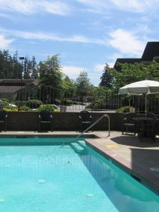 a swimming pool with blue water and an umbrella at Redmond Inn in Redmond