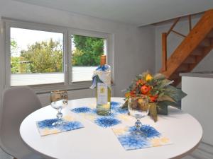 a white table with a bottle of wine and two glasses at Holiday home with terrace in the Harz Mountains in Güntersberge