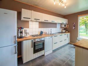 een keuken met witte kasten en witte apparaten bij Lovely Holiday Home in Waimes with Sauna in Ovifat