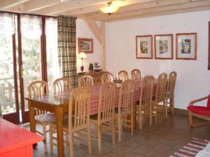 a dining room with a wooden table and chairs at Nice sea view apartment with pool in Valfréjus