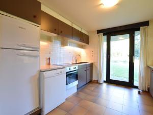 una cucina con elettrodomestici bianchi e una grande finestra di Cozy Villa in Vielsalm with Private Garden a Vielsalm
