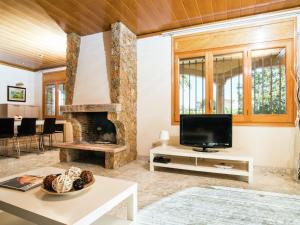 sala de estar con chimenea y TV en Belvilla by OYO Amfora Miro, en Sant Pere Pescador