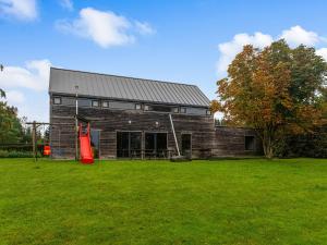 een groot bakstenen gebouw met een rood object in een veld bij Lovely Holiday Home in Waimes with Sauna in Ovifat