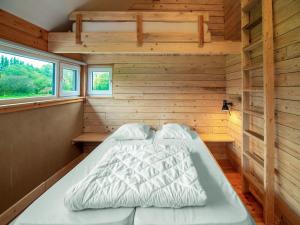 uma cama no canto de um quarto com paredes de madeira em Lovely Holiday Home in Waimes with Sauna em Ovifat