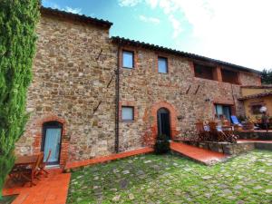 a large brick building with chairs and a yard at Belvilla by OYO Casa Ginepro in San Quirico dʼOrcia