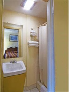 ein Bad mit einem Waschbecken und einem Spiegel in der Unterkunft Rumford Motor Inn in Rumford