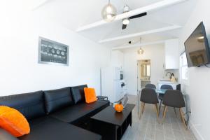 ein Wohnzimmer mit einer schwarzen Couch und einem Tisch in der Unterkunft North Park Bungalow Resort in San Diego