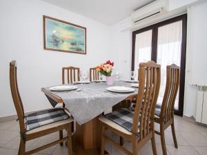 a dining room with a table and four chairs at Modern apartment near the beach in Istria in Vintijan