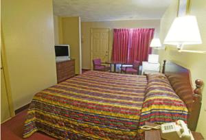 ein Hotelzimmer mit einem Bett mit einer bunten Decke in der Unterkunft Rumford Motor Inn in Rumford