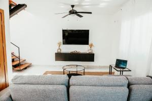 sala de estar con sofá y TV de pantalla plana en Boho Twin Villa 35, en Punta Cana
