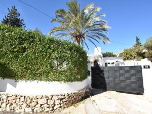 a gate to a house with a palm tree at Belvilla by OYO Villa Rivas in Jávea