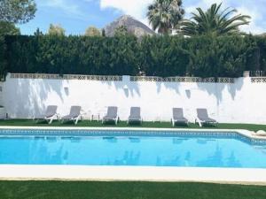 a swimming pool with chairs and a fountain at Belvilla by OYO Villa Rivas in Jávea