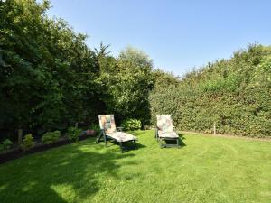 twee stoelen in het gras in een tuin bij Holiday home in the village of Zonnemarie nearby kids beach in Zonnemaire