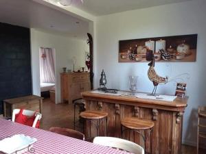 - une cuisine avec un bar avec des tabourets et une table dans l'établissement Chalet near forest lakes and hiking trails, à Raon-lʼÉtape