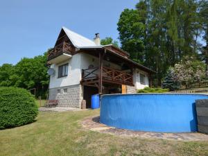 una casa con una valla azul delante de ella en House with the pool and fenced garden, en Hnanice