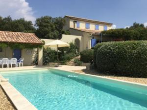 a blue swimming pool in front of a house at Charming Villa in Villes-sur-Auzon with Swimming Pool in Villes-sur-Auzon