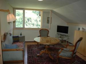 a living room with a table and chairs and a television at Chalet in M rel with Terrace Parking Garden Furniture in Mörel