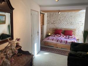 - une chambre avec un lit et des oreillers rouges dans l'établissement Heritage cottage near the forest, à Frontenay-sur-Dive