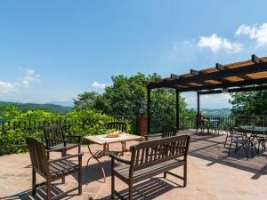 patio ze stołami i krzesłami oraz stołem z widokiem w obiekcie Farmhouse in Umbria with Pool & Views w mieście Biscina