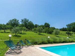 BiscinaにあるFarmhouse in hilly area swimming pool and panoramic terraceのスイミングプールの横に座る椅子
